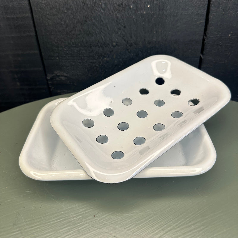 White plastic soap holder on a dark surface