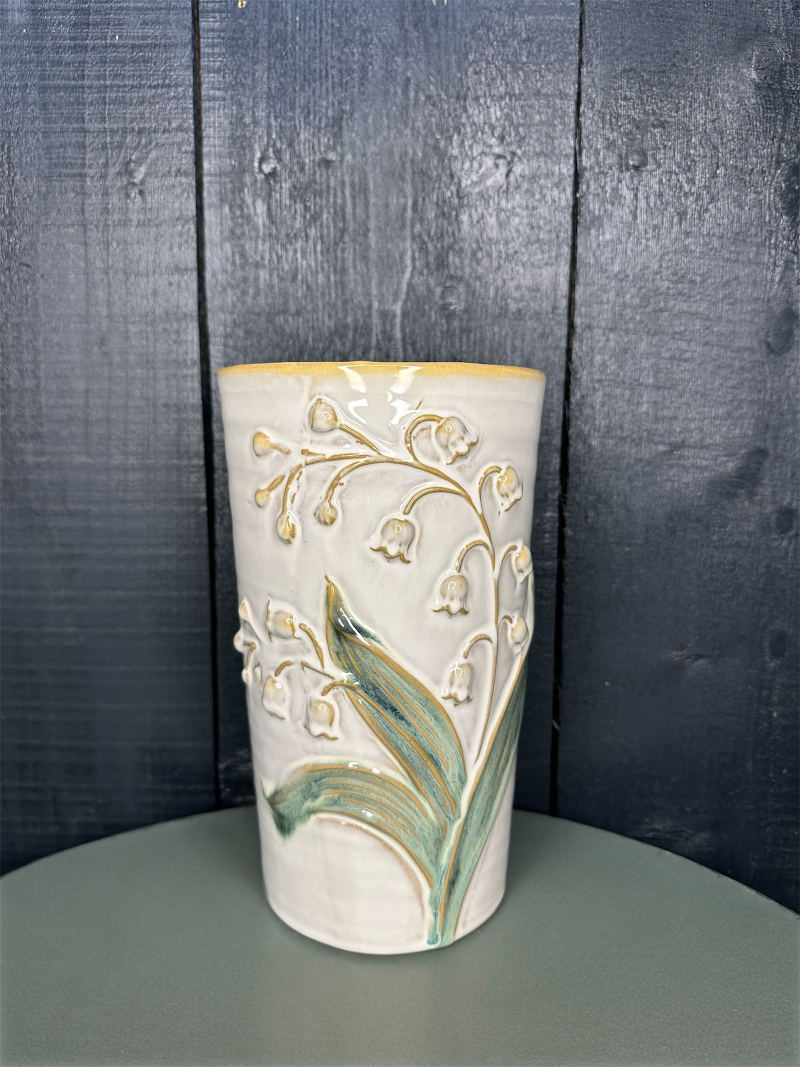 Ceramic vase with floral design on a wooden surface
