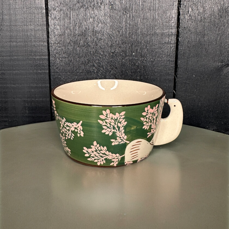 Ceramic mug with floral design on a wooden surface