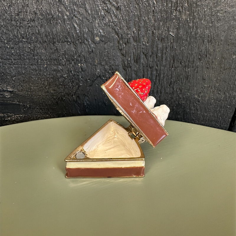 Chocolate dessert with a strawberry on a green surface and black background