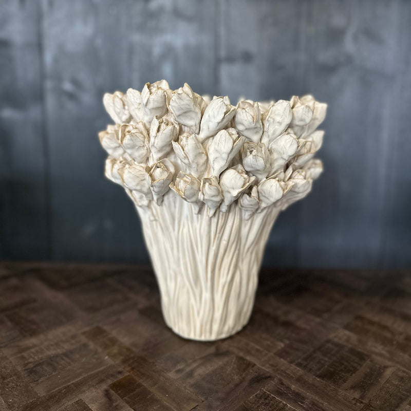 Decorative vase with textured design on a wooden surface and dark background
