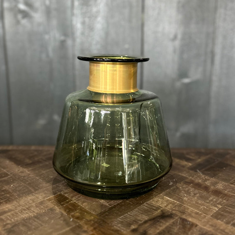 Green glass vase with gold metallic top on a wooden surface