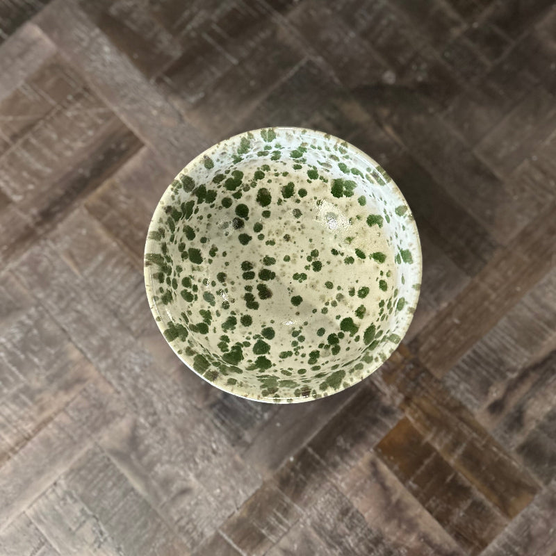 Speckled green bowl on a textured surface