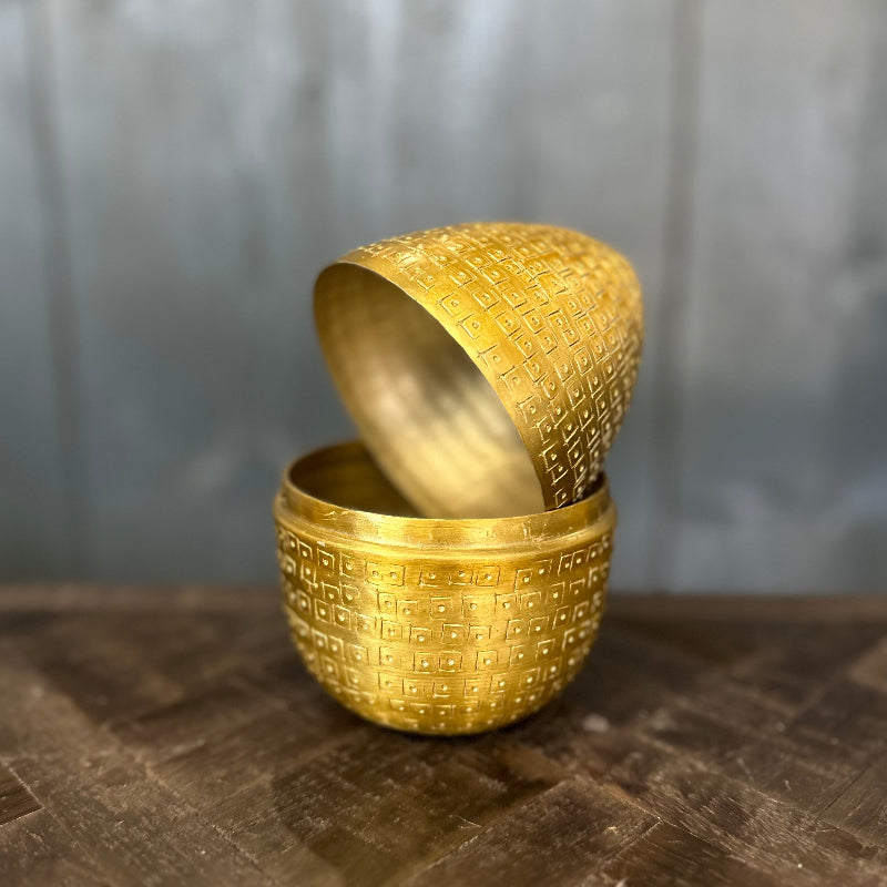 Gold textured container with lid on a wooden surface
