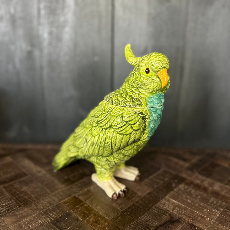Green parrot figurine on a wooden surface with a dark background