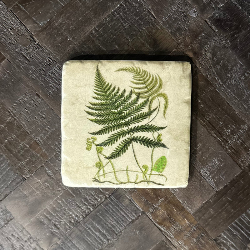 Square coaster with fern design on a wooden surface