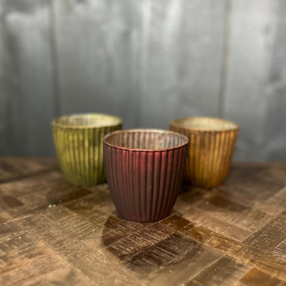 Three metallic cups on a wooden surface with a neutral background