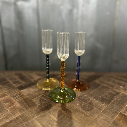 Three decorative glass goblets on a textured surface with a neutral background