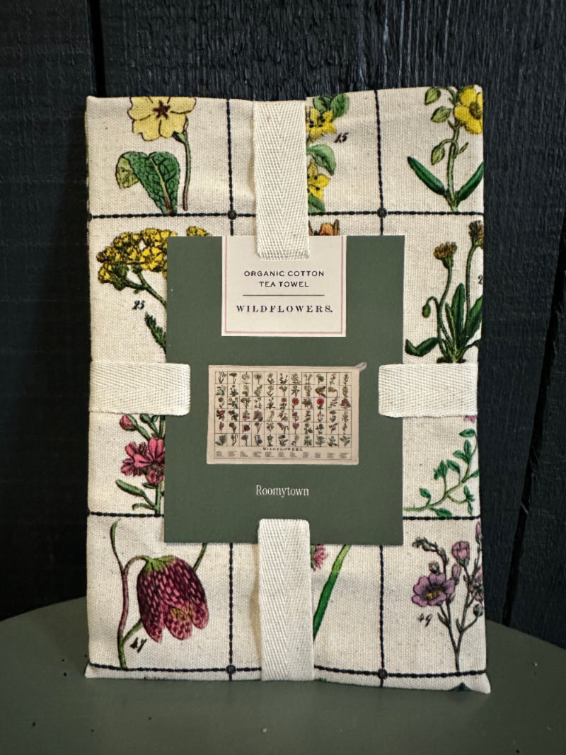 Floral-patterned fabric with a green card and white ribbon on a dark surface