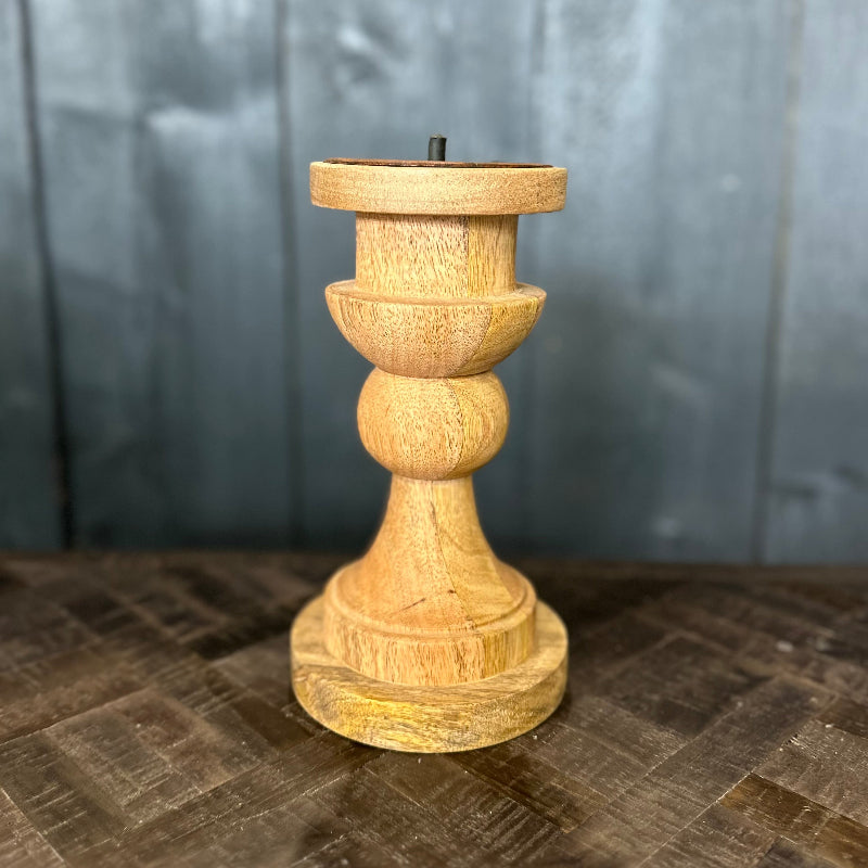 Wooden candle holder on a textured surface with a gray background