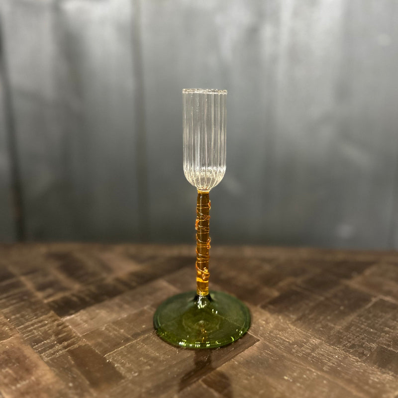 Glass with a textured stem and base on a reflective surface