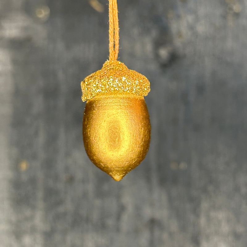 Gold acorn-shaped object on a dark gray background
