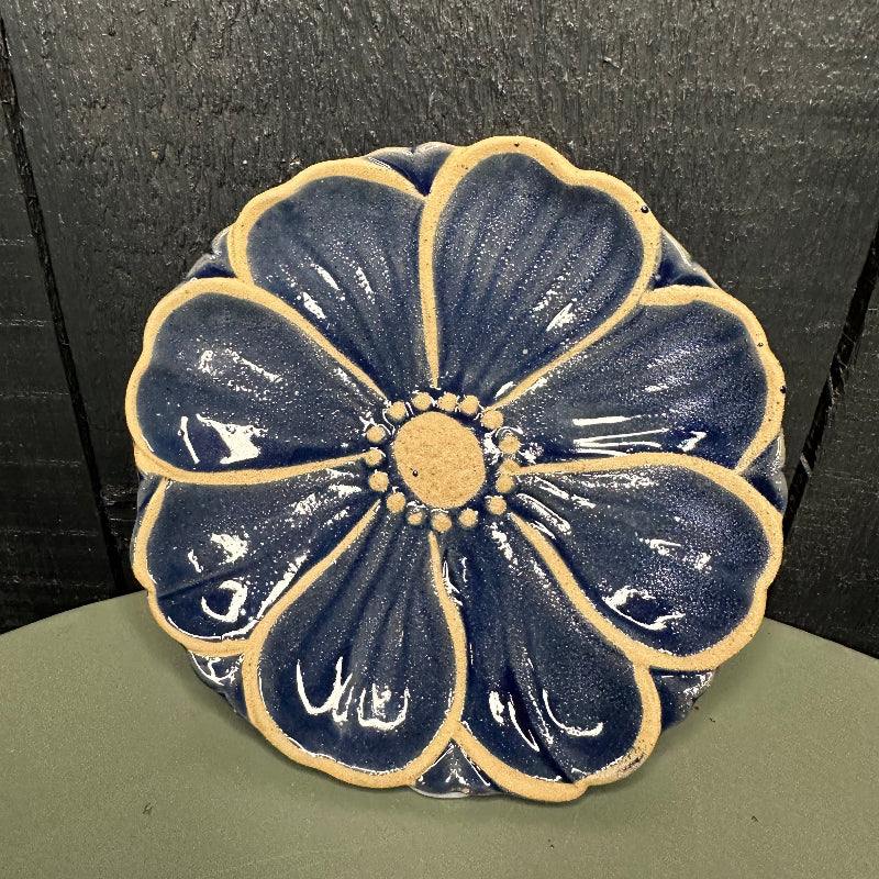 Decorative blue flower-shaped object on a textured surface