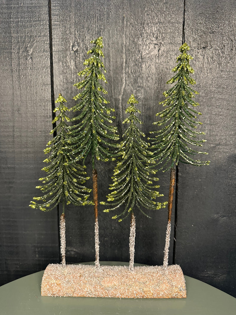 Artificial Christmas tree on a wooden surface with a textured wall background