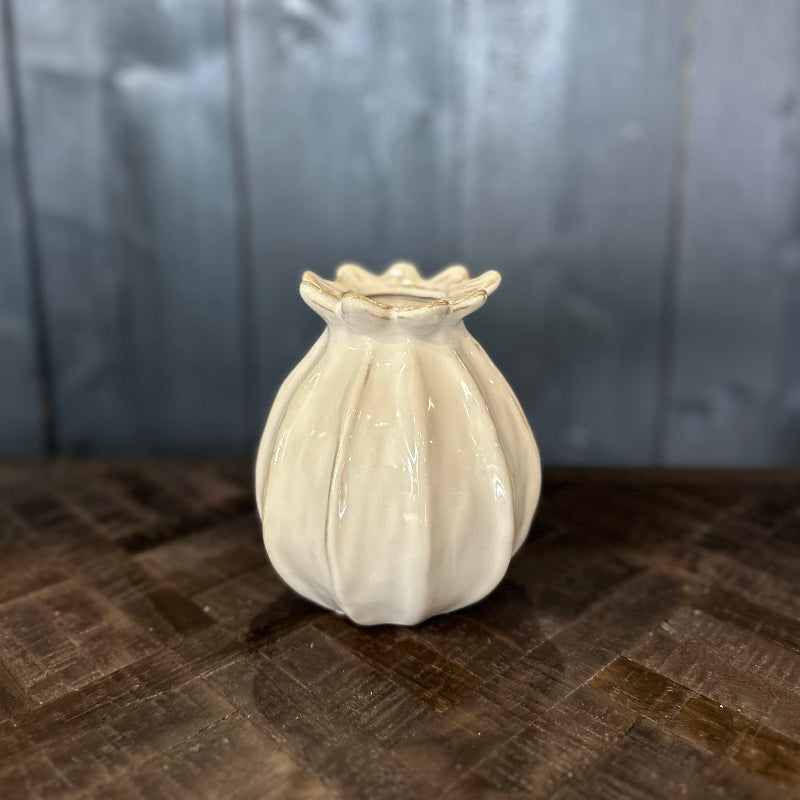 White ceramic vase on a textured surface with a neutral background