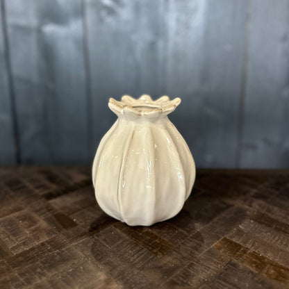 White ceramic vase on a textured surface with a neutral background
