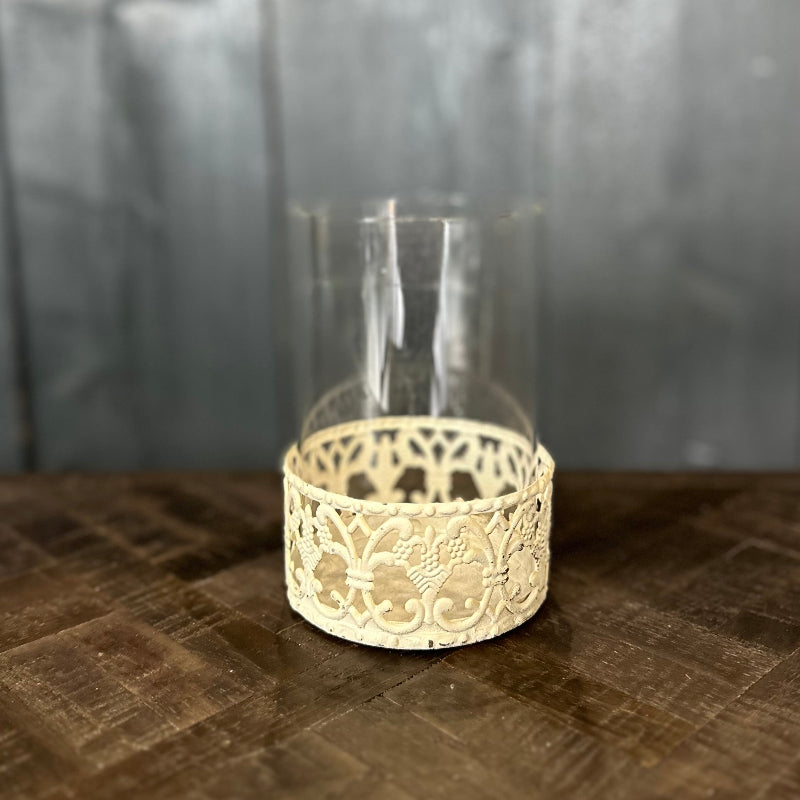 Decorative glass holder with lace-like base on a textured surface