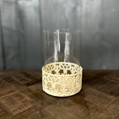 Decorative glass holder with lace-like base on a textured surface