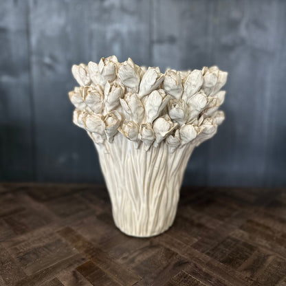 Decorative vase with textured design on a wooden surface and dark background