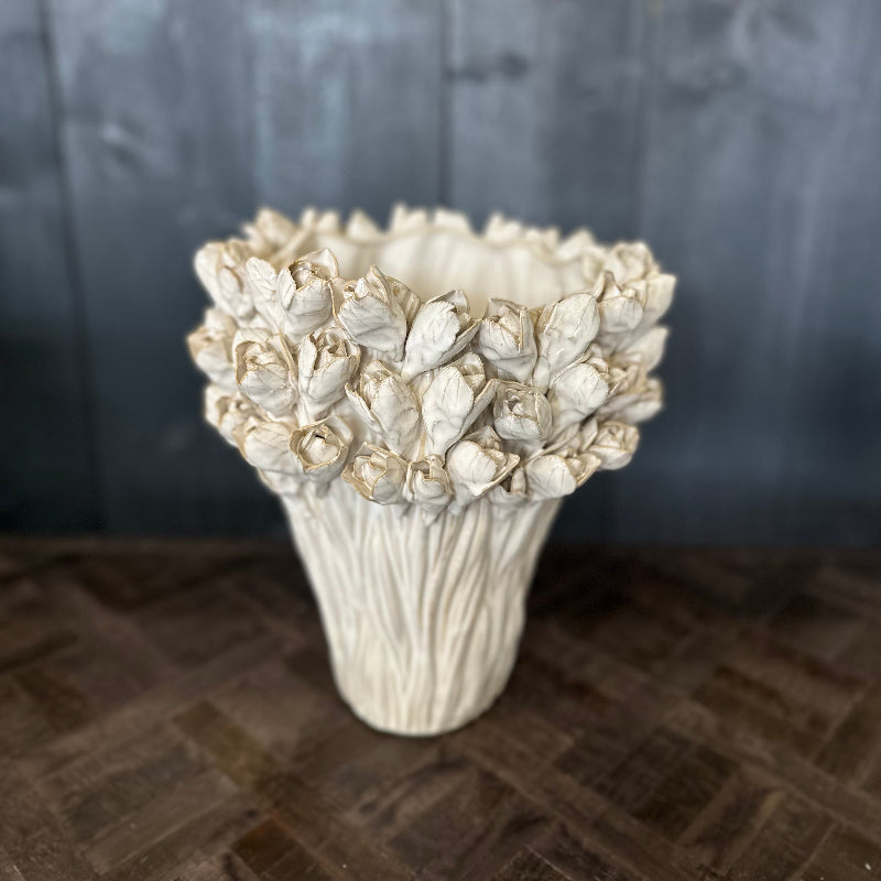 Decorative white vase with floral patterns on a textured surface
