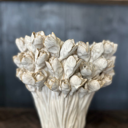White ceramic vase with floral design against a dark background