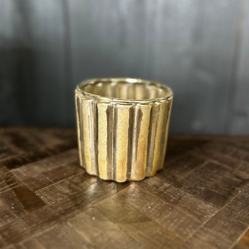 Gold ring with textured design on a wooden surface