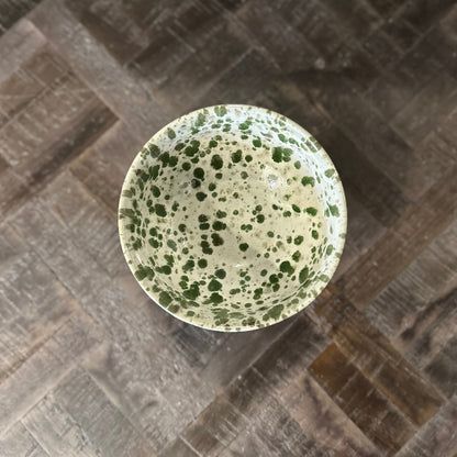 Speckled green bowl on a textured surface