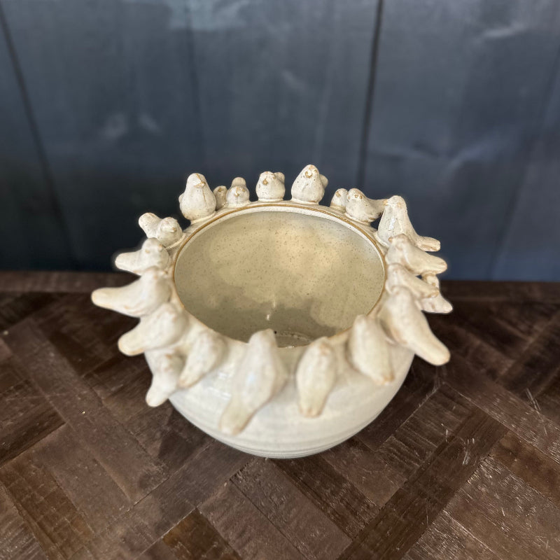 Decorative white bowl with gold interior on a dark surface