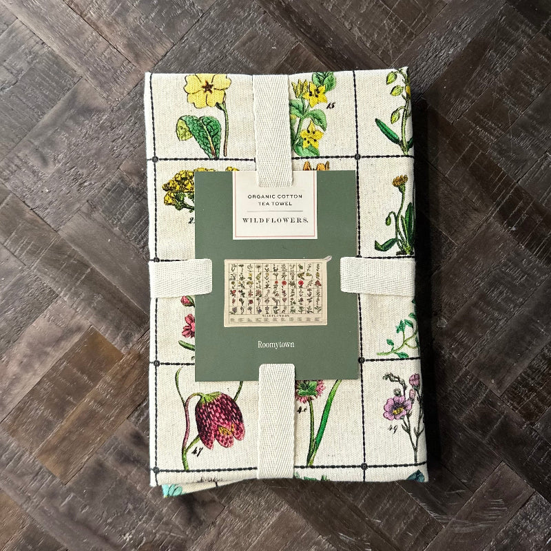 Packaged tea towel with floral design on a wooden surface