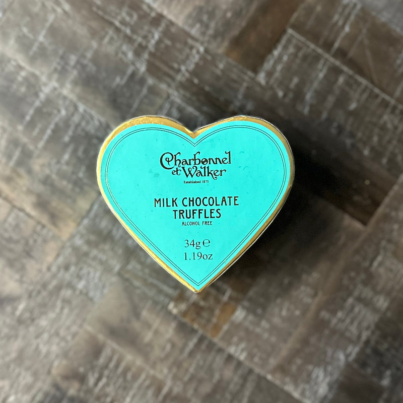 Heart-shaped container of Charbonnel et Walker milk chocolate truffles on a wooden surface