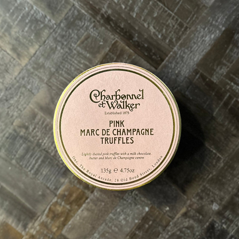 Charbonnel et Walker pink Marc de Champagne truffles packaging on a textured surface