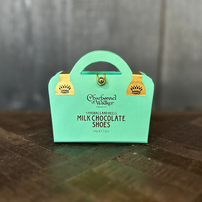 Mint green box of Charbonnel et Walker milk chocolate shoes on a wooden surface.