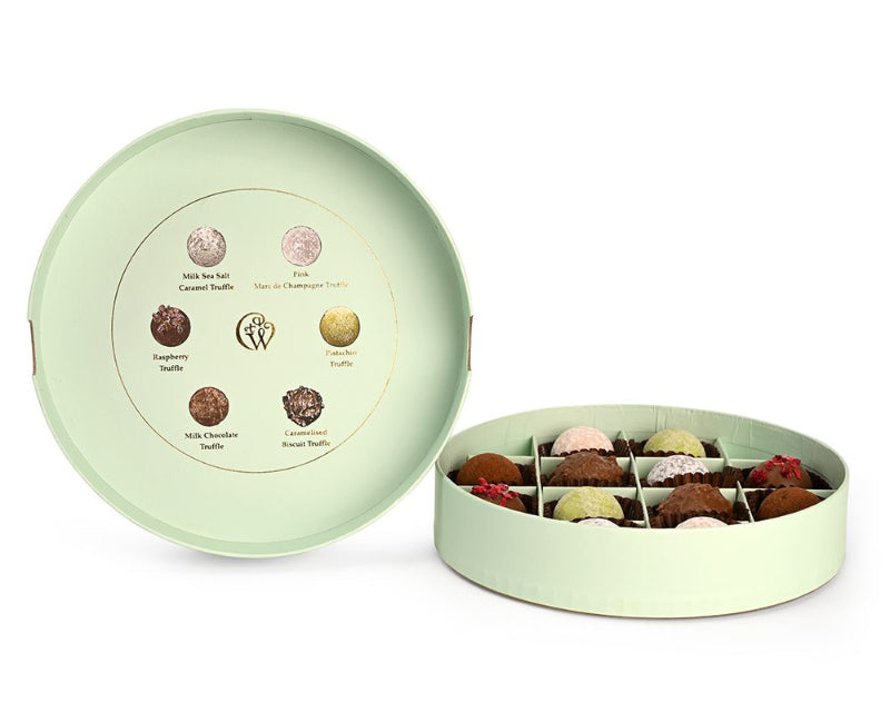 Green round chocolate box with assorted chocolates on a white background