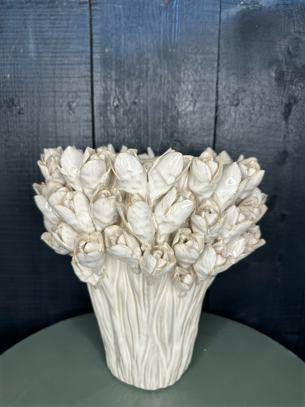 White ceramic vase shaped like a bouquet of roses on a dark wooden surface